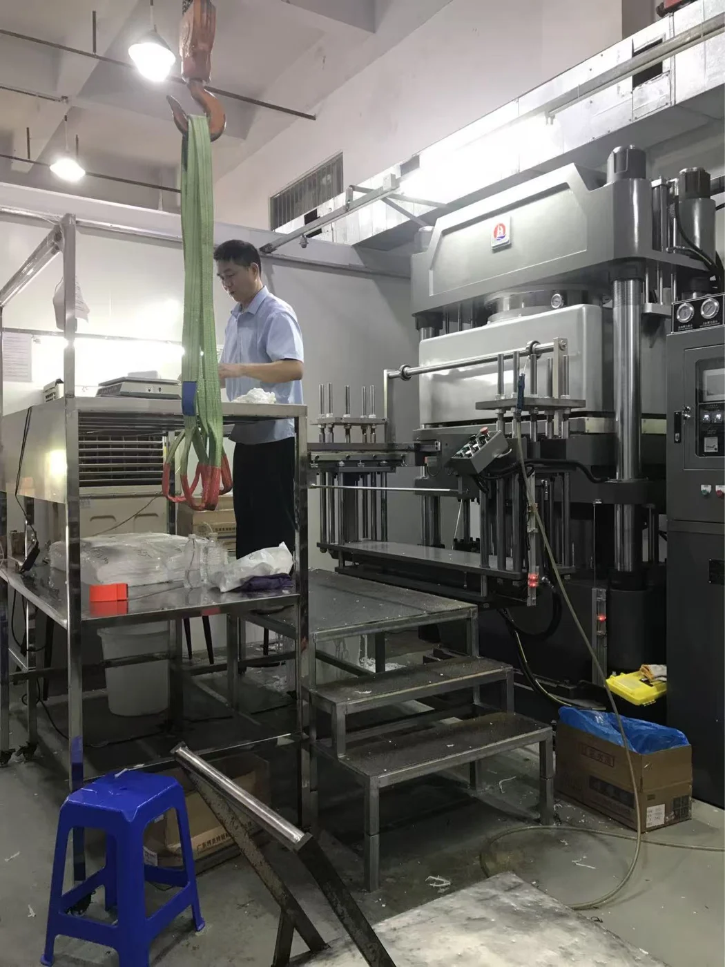 Operator working beside a large hydraulic forming machine