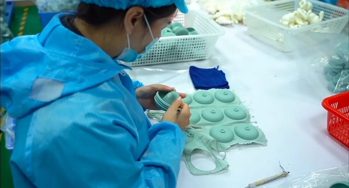 Worker trimming and checking silicone molded parts